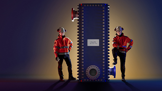 Male and female engineers standing next to Alfa Laval Compabloc welded heat exchanger